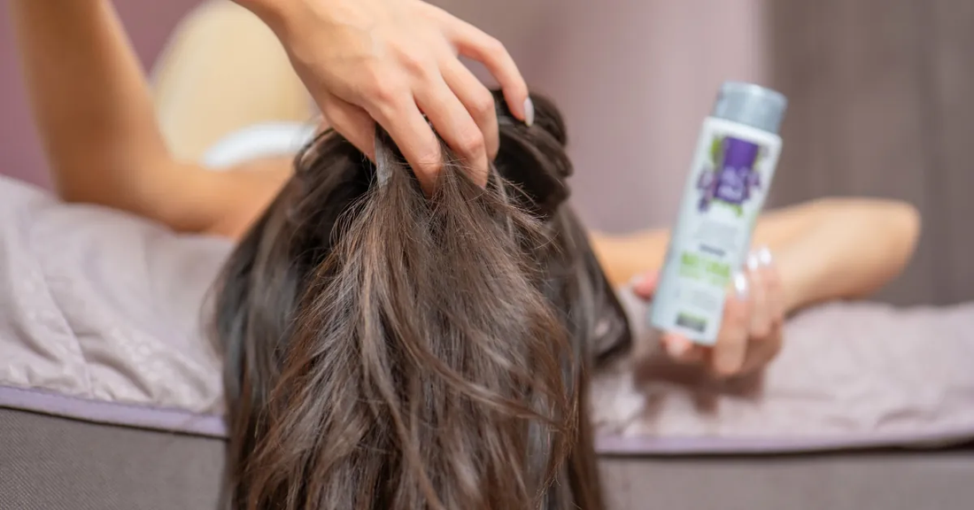Vrouw haalt haar vingers door het haar vanwege jeukende hoofdhuid zonder roos, naast haar Biologisch Saliewater Hydrolina
