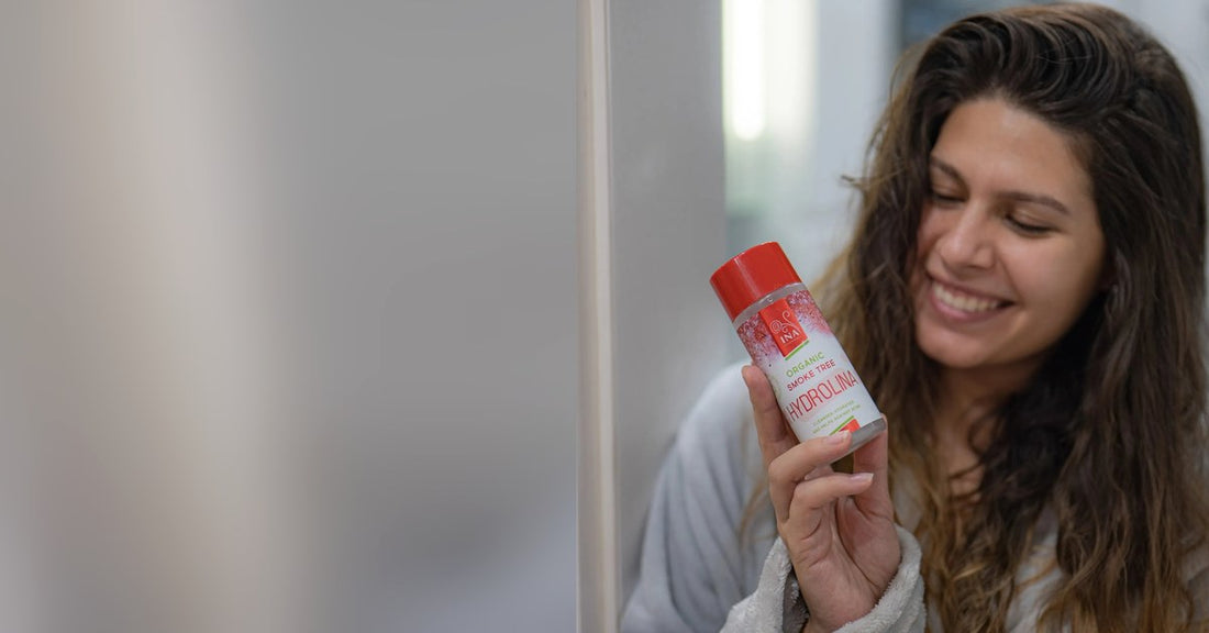 Vrouw met Hydrolina mondwater met pruikenboom voor de spiegel, verzorging bij aften op de tong